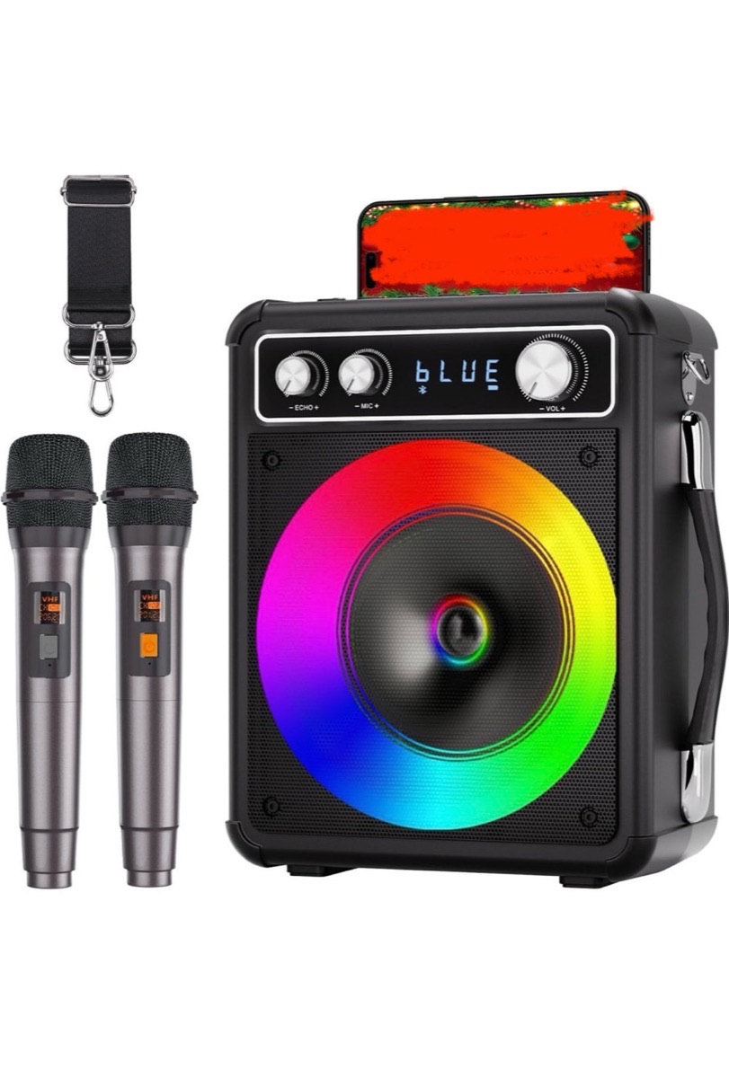 All-in-one karaoke machine with two wireless microphones and a phone dock on top